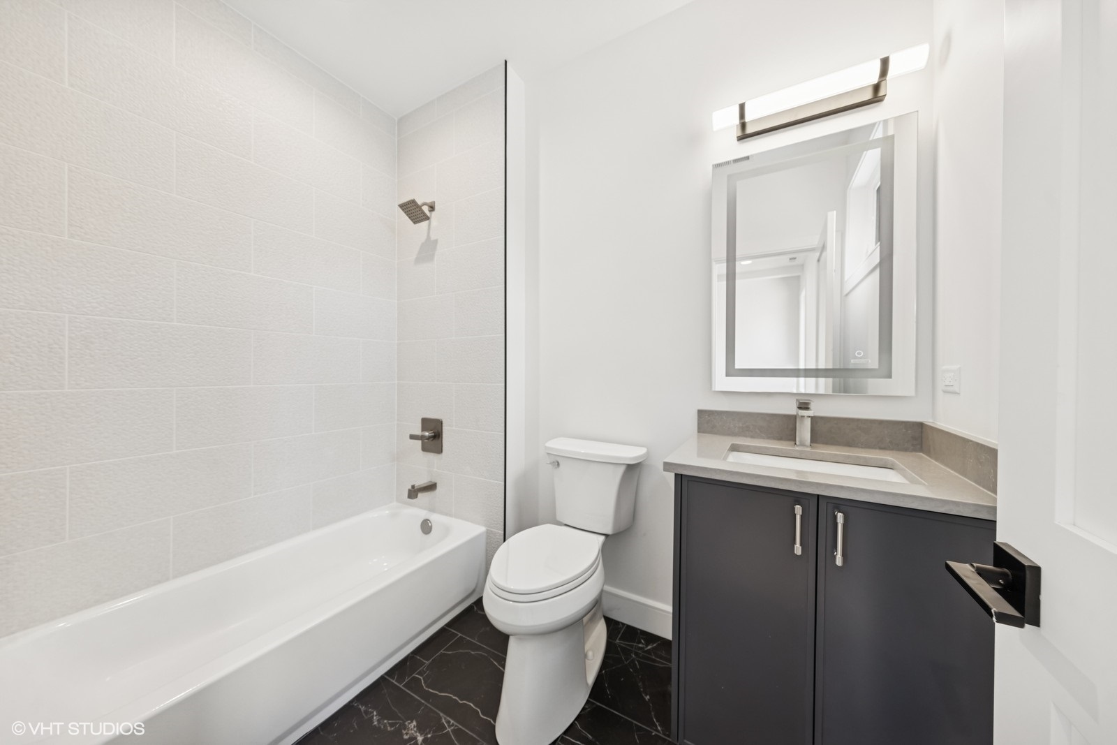 936 Mitchell Avenue Elmhurst, IL 60126 - Photo 23 of 44 a bathroom with a granite countertop sink toilet a large mirror a bathtub and shower