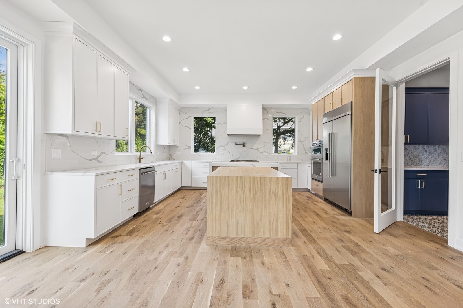 936 Mitchell Avenue Elmhurst, IL 60126 - Photo 4 of 44 a large white kitchen with a stove a sink dishwasher and a refrigerator with wooden floor