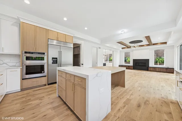 a large kitchen with stainless steel appliances kitchen island granite countertop a refrigerator and a stove top oven