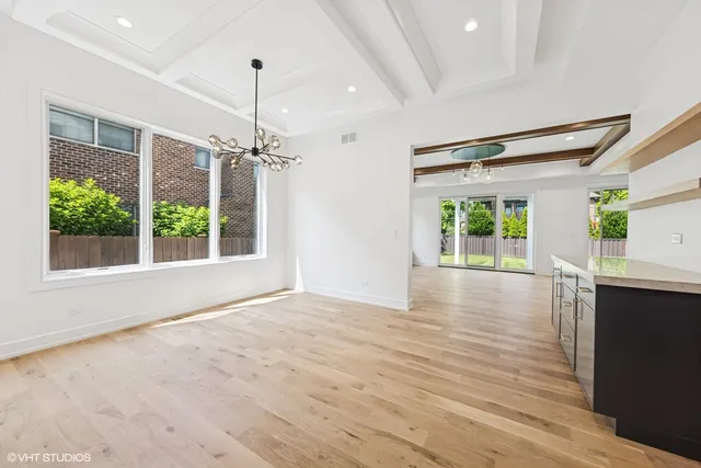 a view of a room with wooden floor a ceiling fan and window
