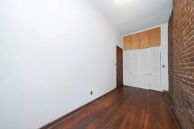 a view of a room with wooden floor