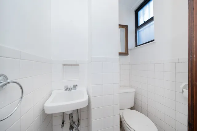 a bathroom with a toilet sink and mirror