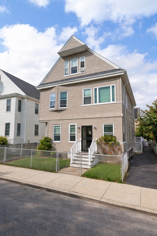 a front view of a house with garage and parking