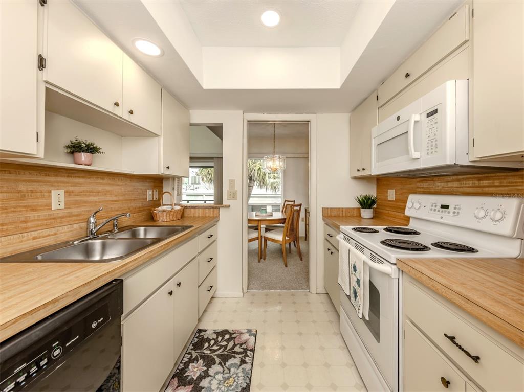 1555 Tarpon Center Drive, Unit 261 Venice, FL 34285 - Photo 14 of 50 a kitchen with a stove sink and cabinets
