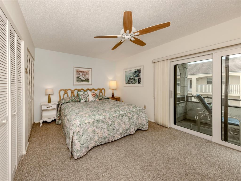 1555 Tarpon Center Drive, Unit 261 Venice, FL 34285 - Photo 15 of 50 a spacious bedroom with a bed and a chandelier