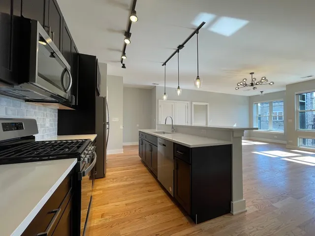 a kitchen with stainless steel appliances granite countertop a stove a sink and a refrigerator