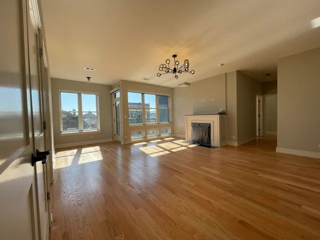 an empty room with wooden floor and fireplace
