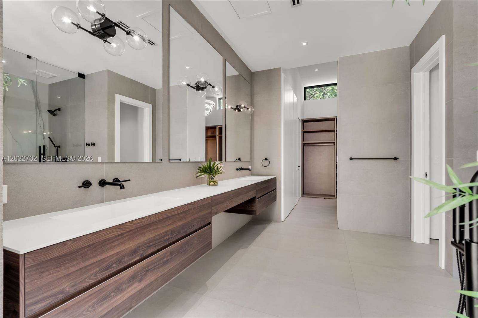 7825 Southwest 128th Street Pinecrest, FL 33156 - Photo 26 of 88 a large bathroom with a double vanity sink a large mirror and shower