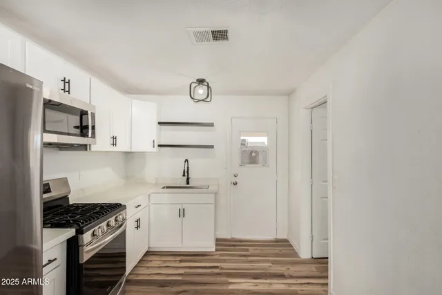 a kitchen with stainless steel appliances a sink stove and refrigerator