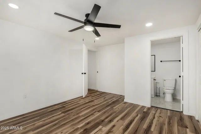 a view of a room with wooden floor and a ceiling fan