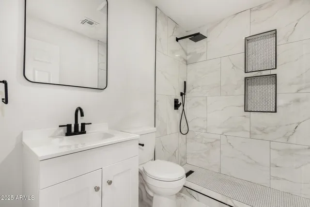 a bathroom with a sink a toilet and shower