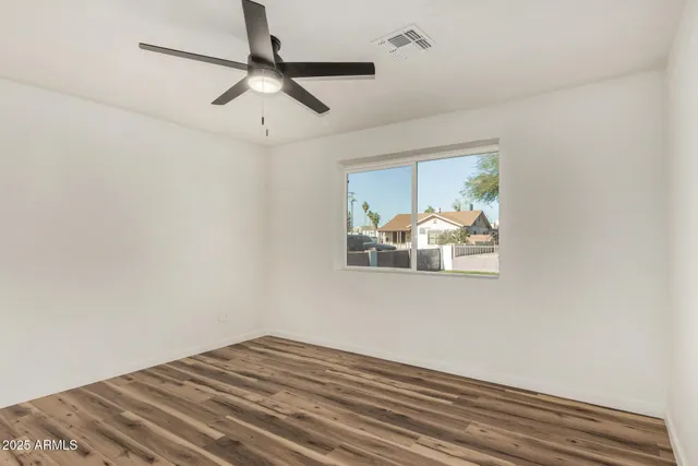 a view of a room with wooden floor chandelier fan and windows