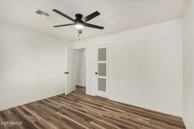 a view of a livingroom with wooden floor and a ceiling fan