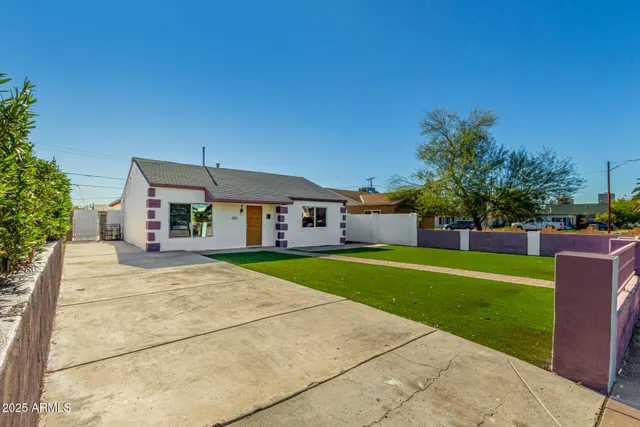 a front view of house with yard and trees in the background