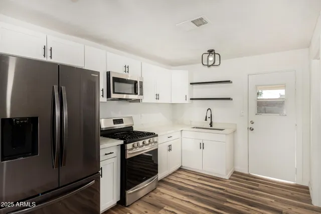 a kitchen with stainless steel appliances a refrigerator stove and sink