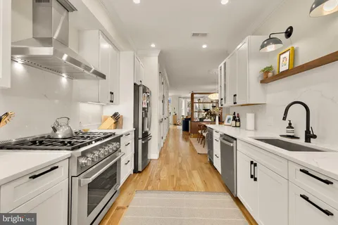 a kitchen with stainless steel appliances granite countertop a sink stove and cabinets