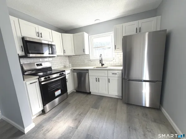 a kitchen with a refrigerator stove and sink