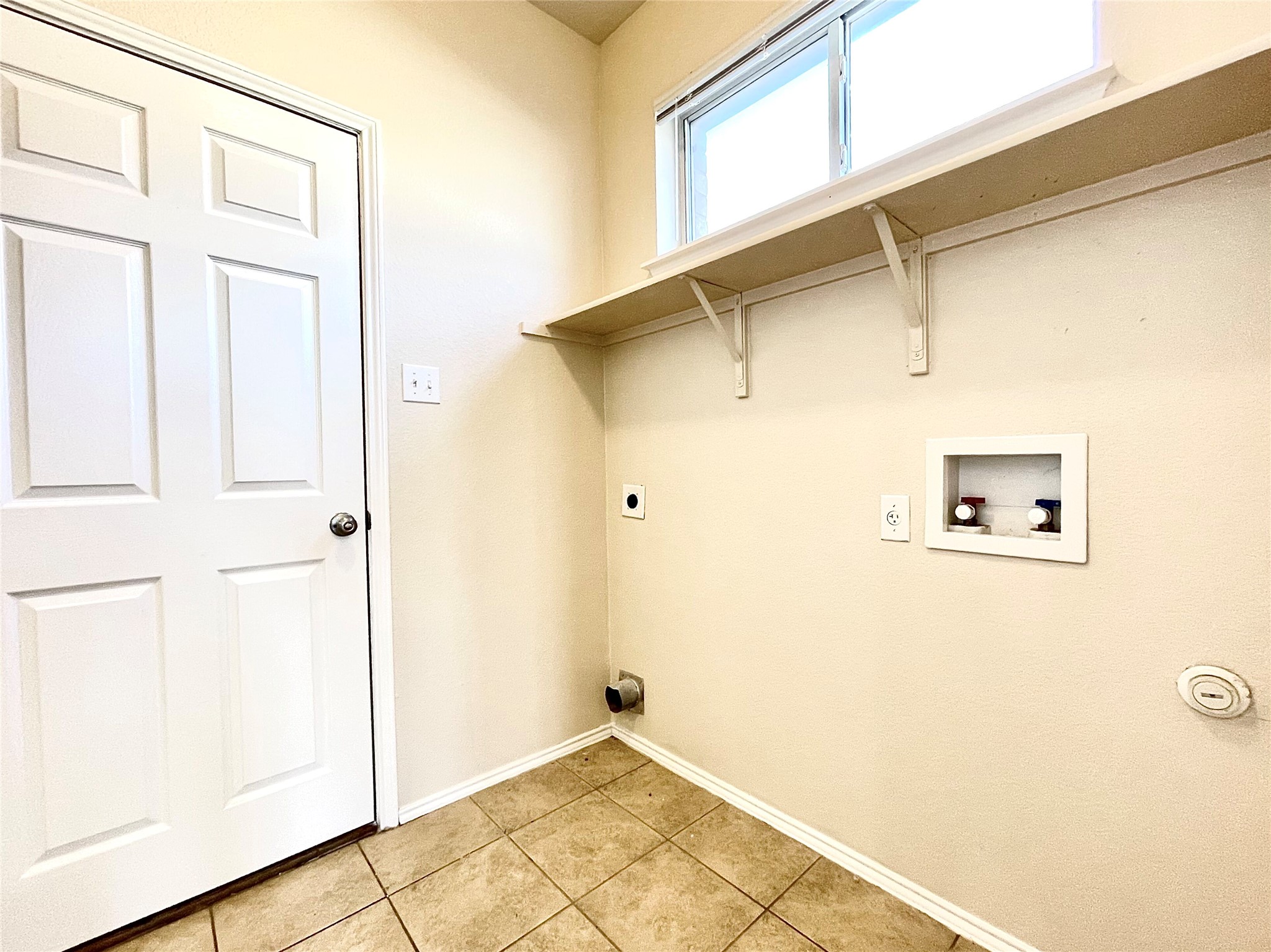 508 Emma Rose Trail Leander, TX 78641 - Photo 33 of 40 A well-appointed utility area with ample shelving and tiled floors awaits laundry day tasks.