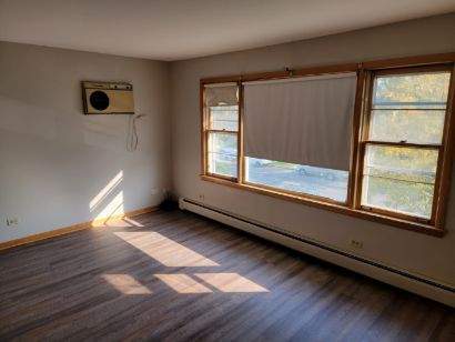 7824 West Addison Street, Unit 2 Chicago, IL 60634 - Photo 12 of 28 a view of an empty room with wooden floor and a window