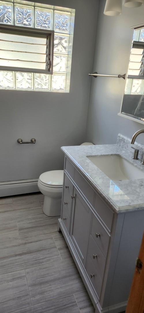 7824 West Addison Street, Unit 2 Chicago, IL 60634 - Photo 13 of 28 a bathroom with a granite countertop toilet sink and mirror