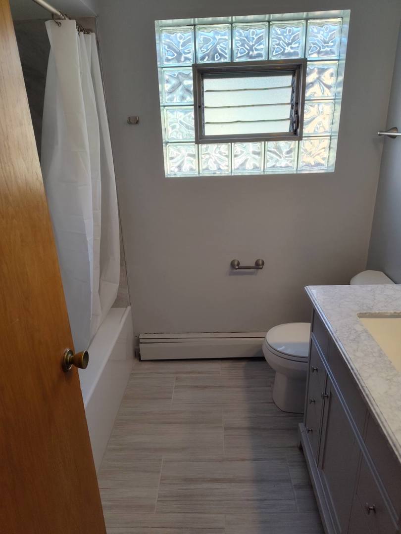 7824 West Addison Street, Unit 2 Chicago, IL 60634 - Photo 15 of 28 a bathroom with a toilet sink and window