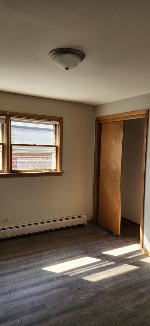 7824 West Addison Street, Unit 2 Chicago, IL 60634 - Photo 19 of 28 a view of empty room with wooden floor and window