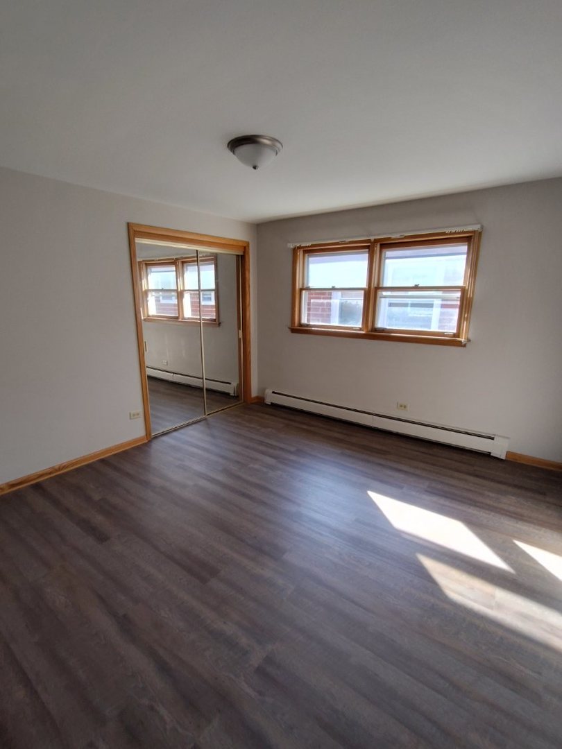 7824 West Addison Street, Unit 2 Chicago, IL 60634 - Photo 24 of 28 a view of empty room with wooden floor and fan