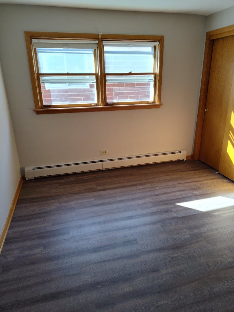 7824 West Addison Street, Unit 2 Chicago, IL 60634 - Photo 27 of 28 a view of an empty room with wooden floor and a window