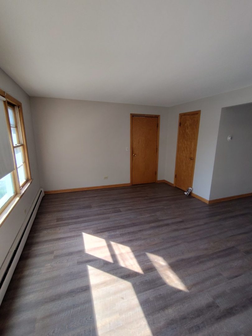 7824 West Addison Street, Unit 2 Chicago, IL 60634 - Photo 10 of 28 a view of an empty room with wooden floor and a window