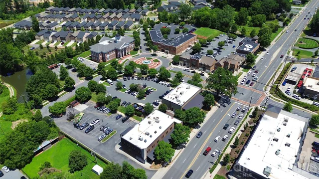 an aerial view of residential houses with outdoor space and parking