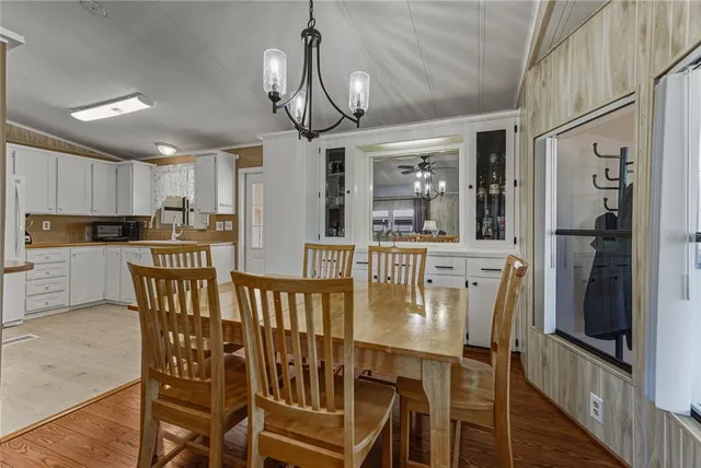 a kitchen with stainless steel appliances kitchen island granite countertop a dining table chairs and granite counter tops