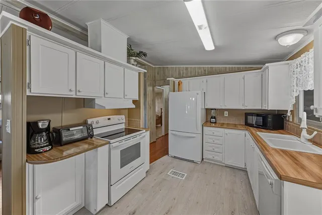 a kitchen with white cabinets and white appliances