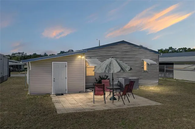 a view of backyard with table and chairs under an umbrella