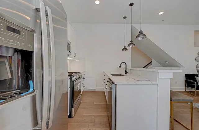 a kitchen with stainless steel appliances granite countertop a sink a stove and a refrigerator