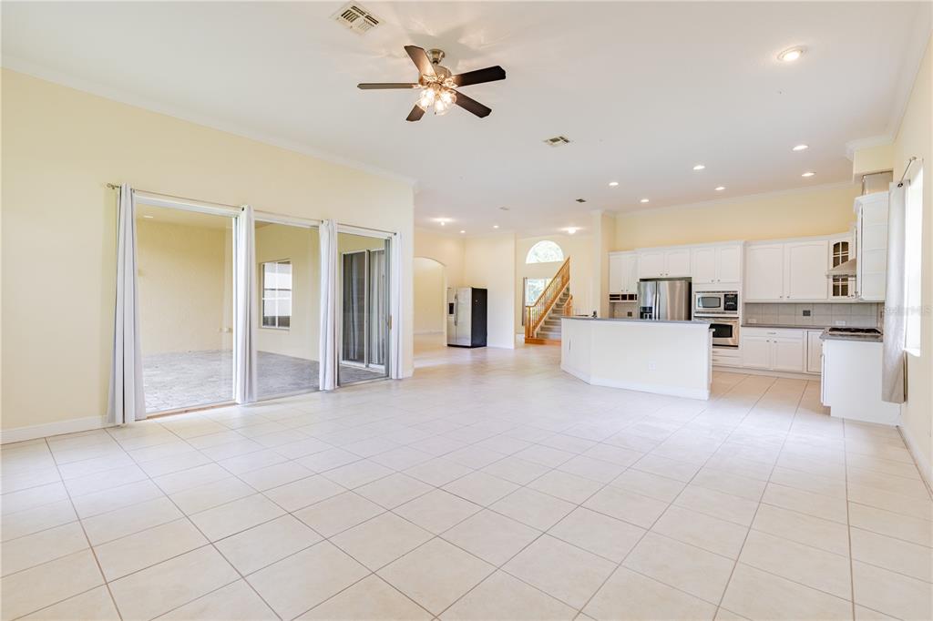 2718 Knightsbridge Road Clermont, FL 34711 - Photo 23 of 72 a view of a livingroom with furniture a ceiling fan and kitchen view