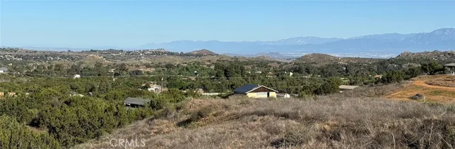 a view of a dry yard with mountains in the background