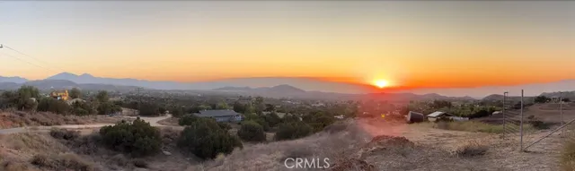 a view of a dry yard with mountains in the background