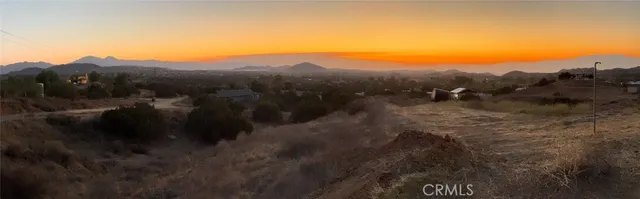 a view of a forest with mountains in the background