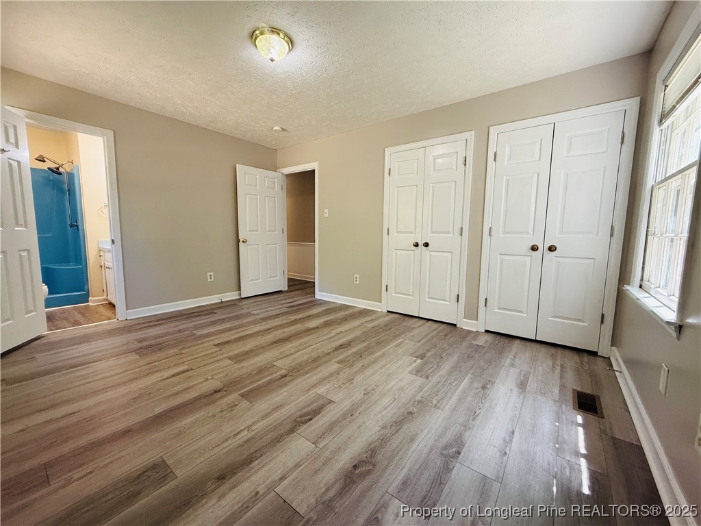 4355 Draughon Road Eastover, NC 28312 - Photo 11 of 20 an empty room with wooden floor and windows
