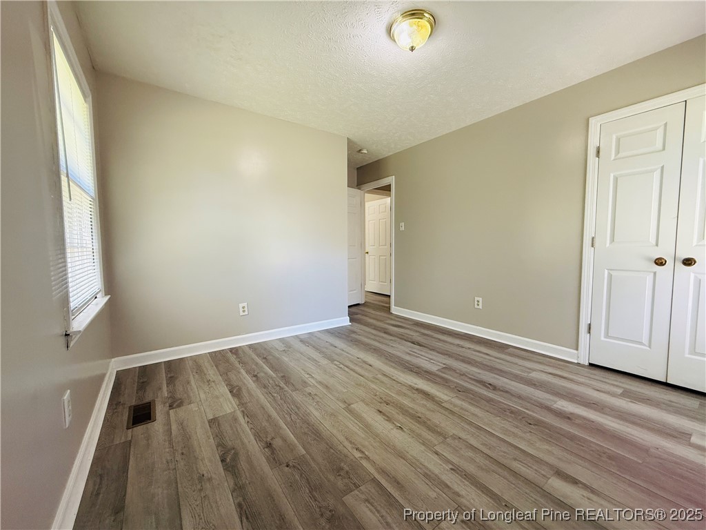 4355 Draughon Road Eastover, NC 28312 - Photo 16 of 20 an empty room with wooden floor and windows