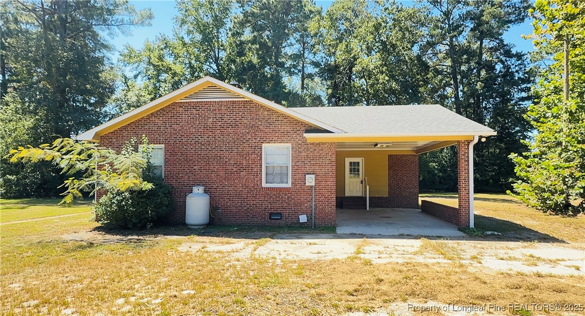 4355 Draughon Road Eastover, NC 28312 - Photo 19 of 20 a backyard of a house with table and chairs under an umbrella