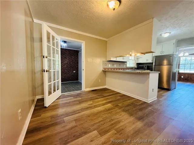 a view of a kitchen with a sink wooden floor and a window