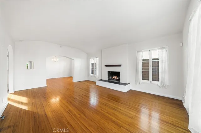 a view of empty room with wooden floor and fireplace