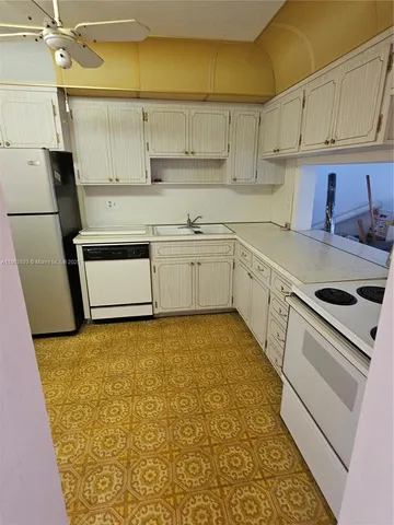 a kitchen with sink cabinets and appliances