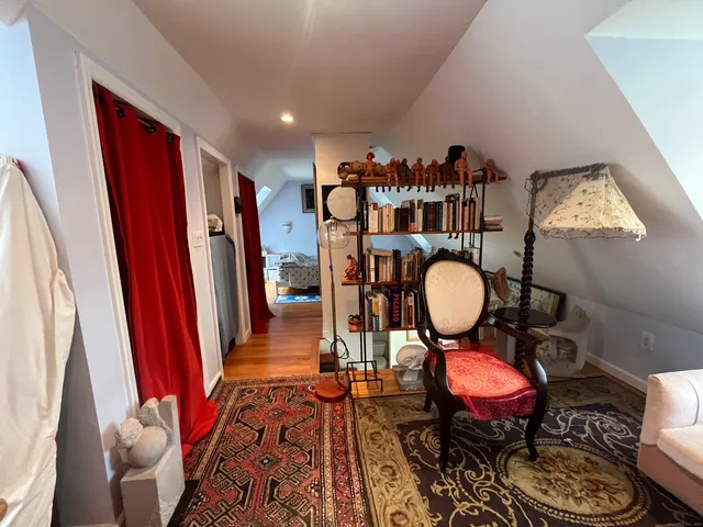 a living room with furniture a rug and white walls