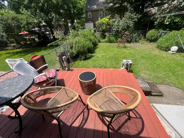 a view of a backyard with table and chairs with wooden floor and fence