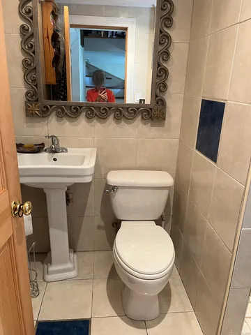 a bathroom with a toilet sink and mirror
