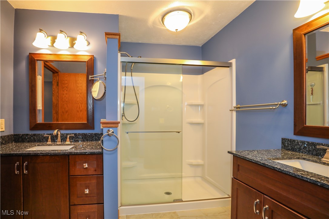 12565 Alpha Road Hiram, OH 44234 - Photo 26 of 50 Bathroom with two vanities, a stall shower, and a sink
