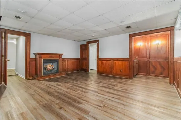 a view of empty room with wooden floor and fireplace
