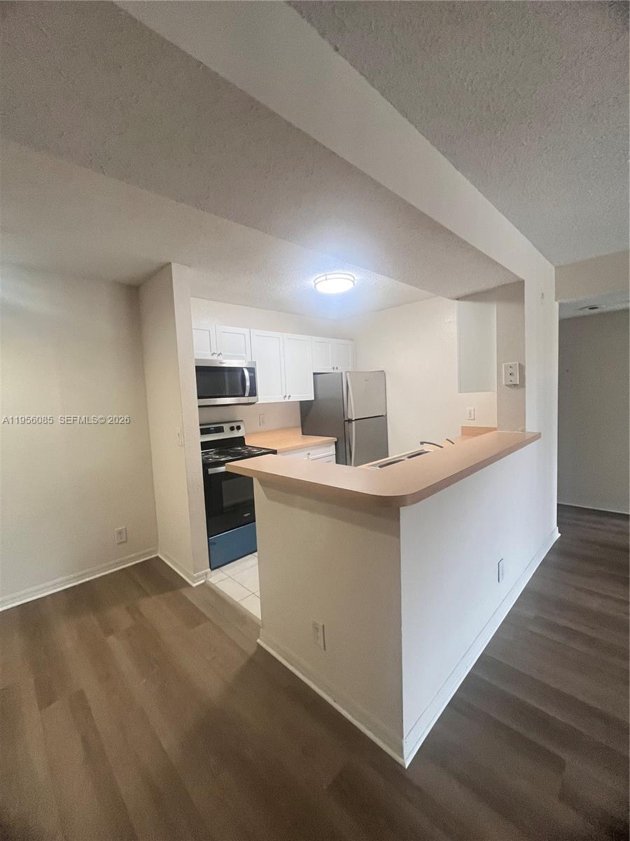 a kitchen with stainless steel appliances kitchen island a sink refrigerator and cabinets
